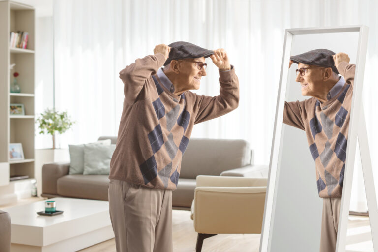 Elderly gentleman getting ready in front of a mirror at home